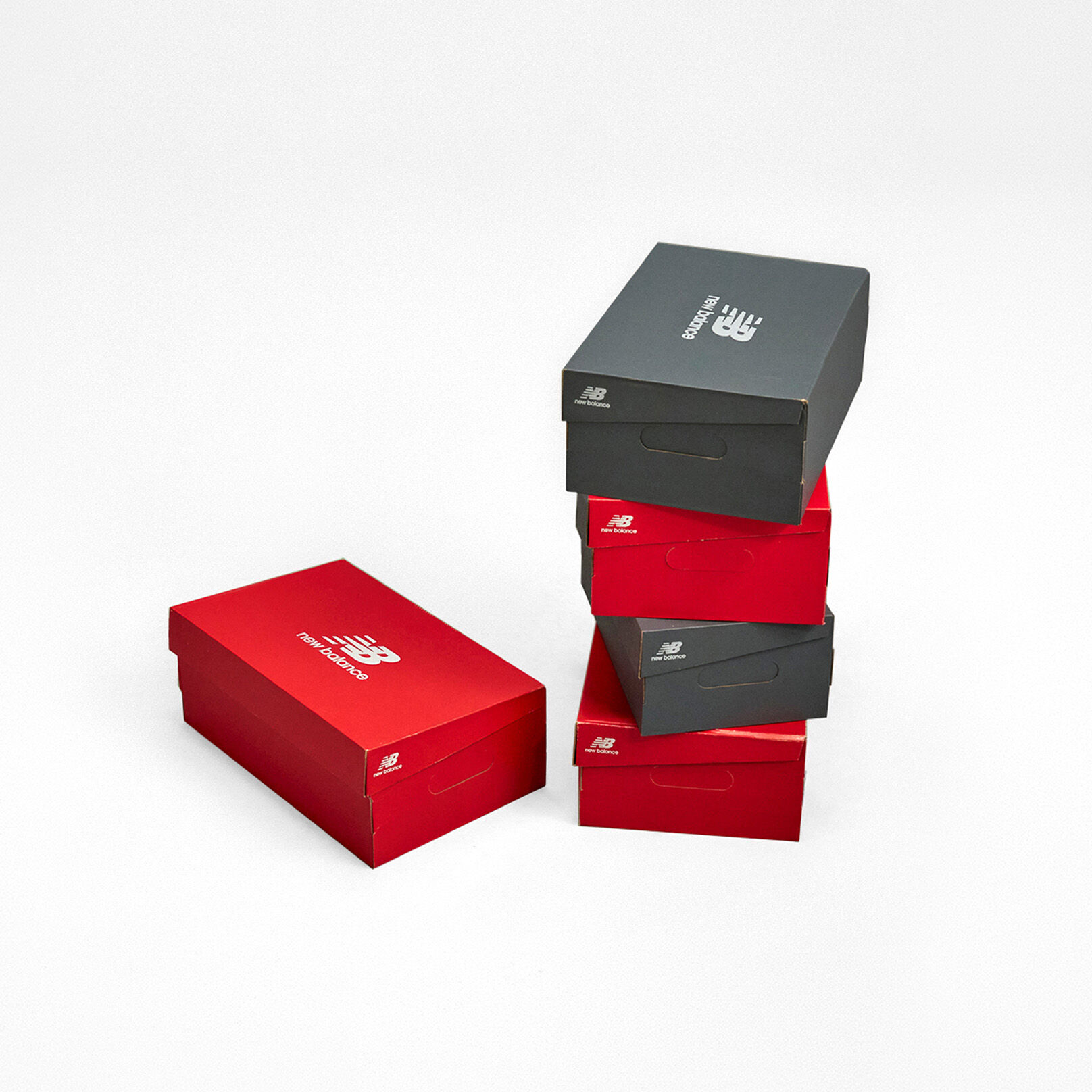 ajas de zapatos New Balance rojas y grises apiladas.